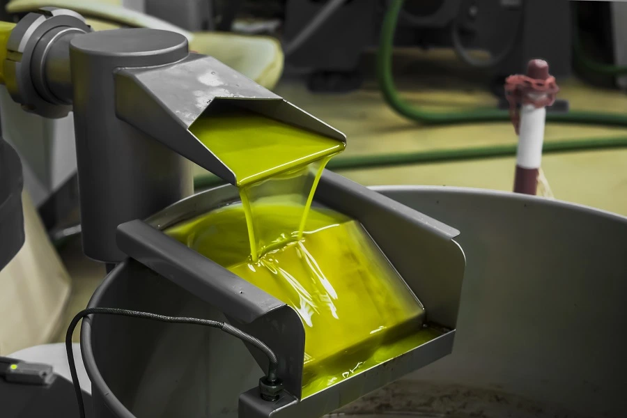 olive oil pouring into tank in factory